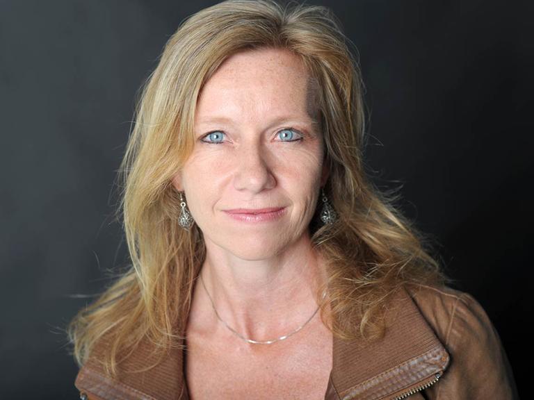 Die Autorin Christine Brand lächelt auf einem Porträt ruhig in die Kamera.