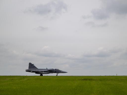 Kampfjet aus Tschechien steht in Island auf einer grünen Wiese vor bewölktem Himmel.