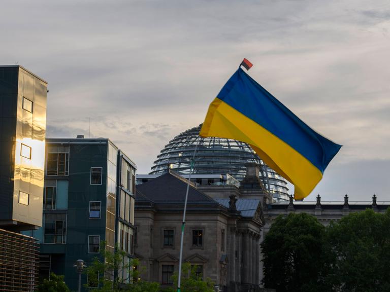Eine Ukraine-Flagge weht bei einer Demonstration gegen den russischen Angriffskrieg vor dem Bundestag in Berlin (Archivbild)