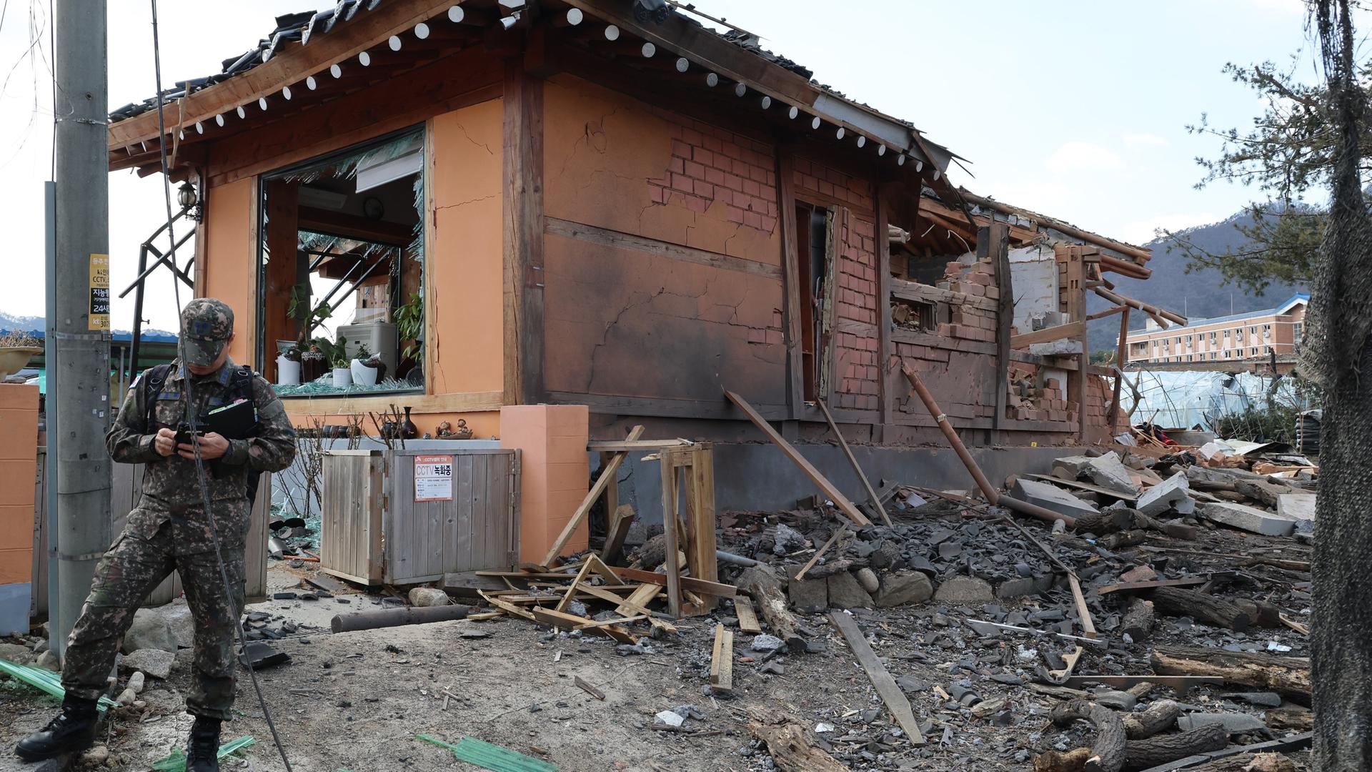 Pocheon: Ein Soldat steht vor einem Haus in Tümmern. Pocheon: Ein Soldat steht vor einem Haus in Tümmern.
