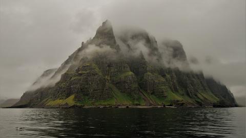 Zerklüftete Berge einer Insel im Nebel.