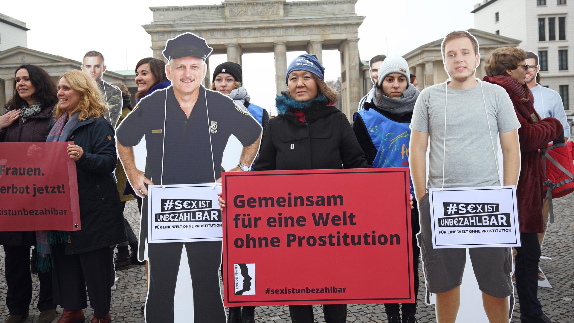Demonstranten stehen vor dem Brandenburger Tor in Berlin und halten Schilder hoch, auf denen ein Sexkaufverbot gefordert wird.