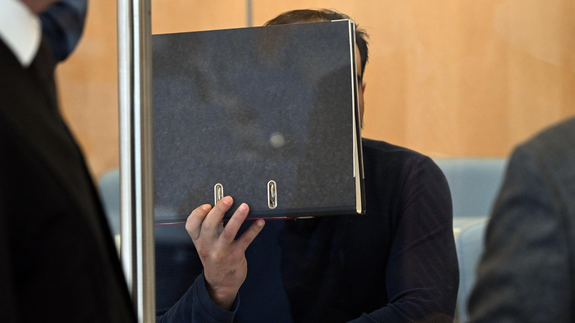 Ein Angeklagter sitzt vor Prozessbeginn im Gerichtssaal. 