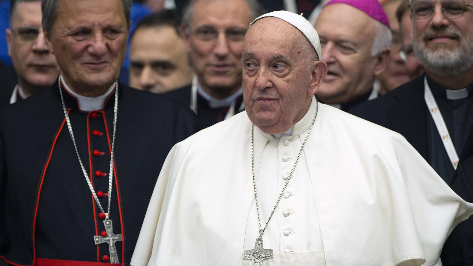 Papst Franziskus blickt zur Seite, neben ihm stehen andere Geistliche. (26.10.2024)