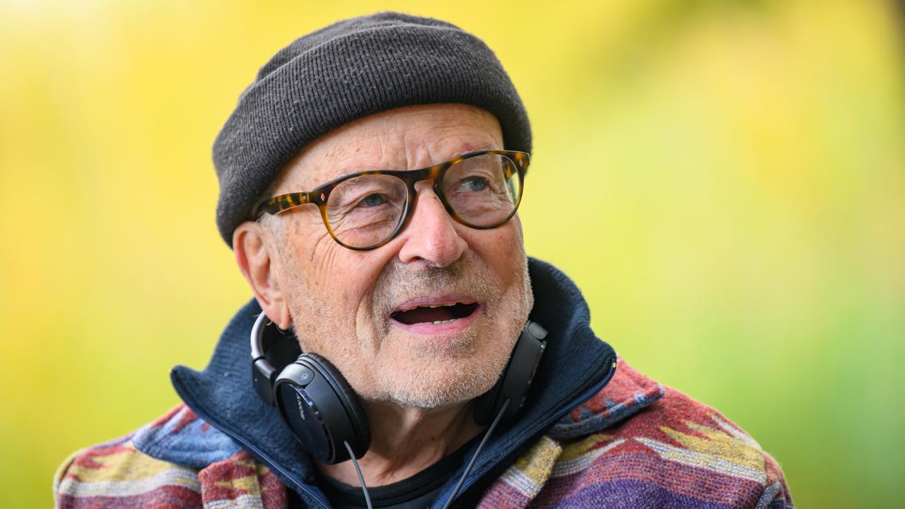 Volker Schlöndorff von den Schultern an aufwärts. Er trägt eine schwarze Wollmütze, Kopfhörer hängen an seinem Hals. 