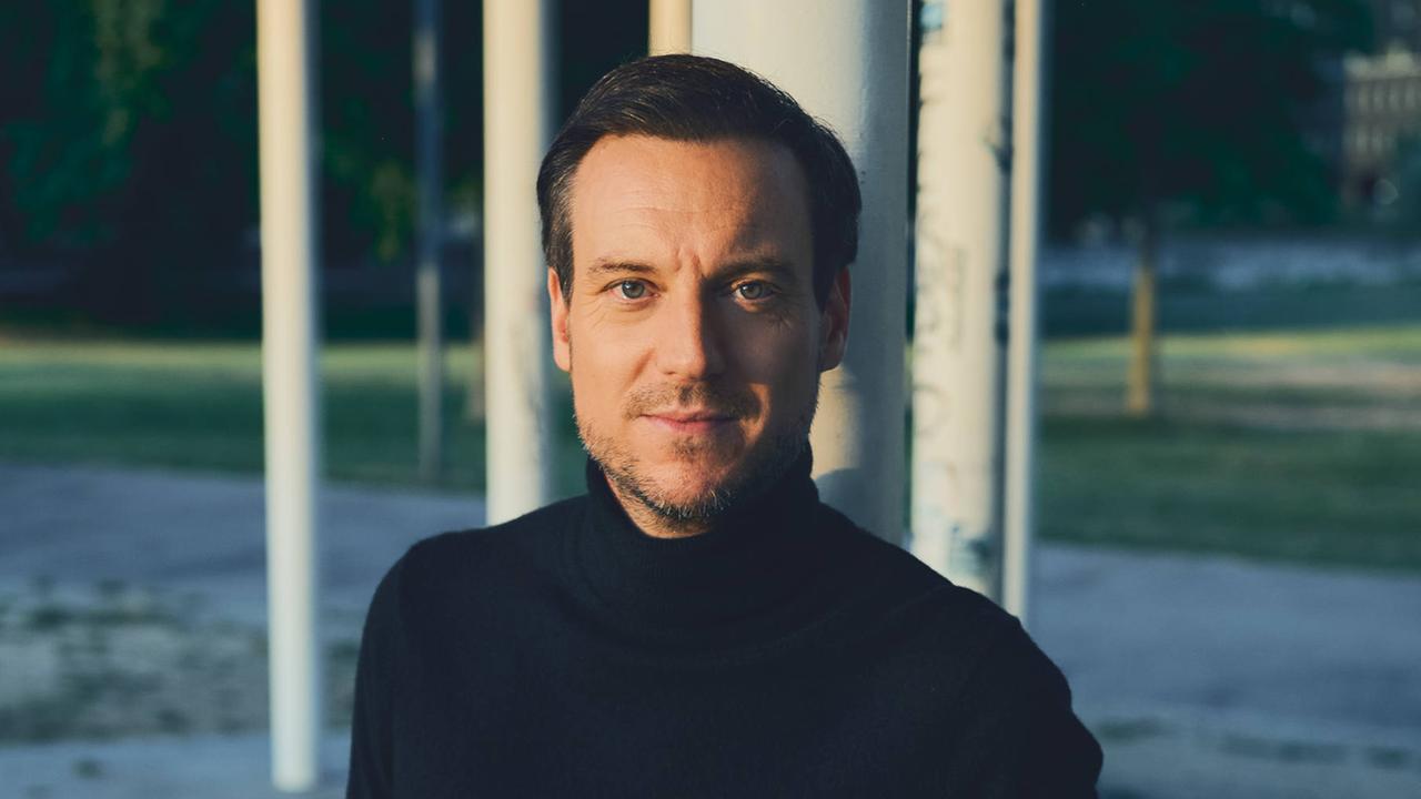 Journalist und Autor Andreas Wunn schaut direkt in die Kamera. Er trägt einen schwarzen Rollkragenpullover.