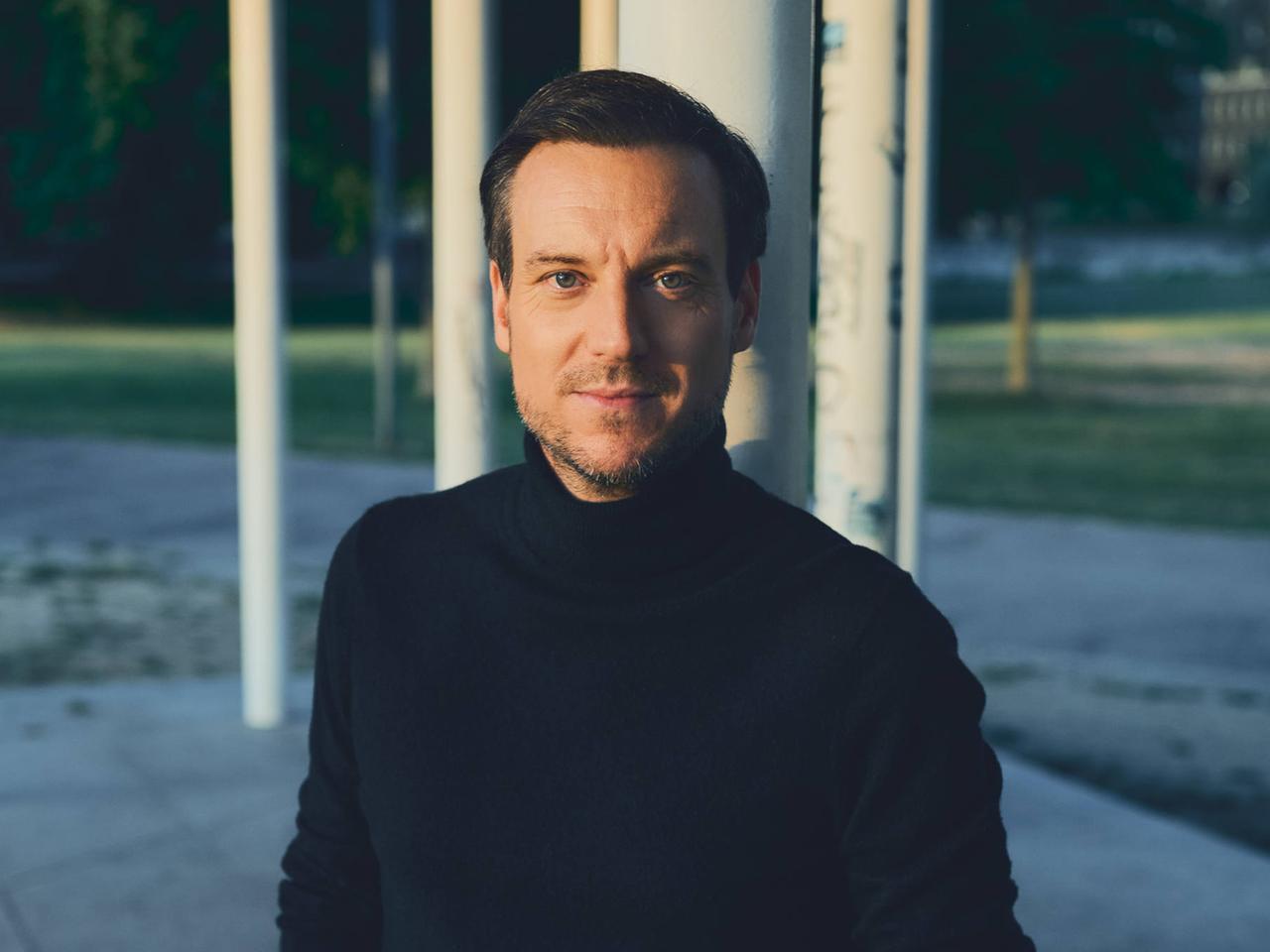 Journalist und Autor Andreas Wunn schaut direkt in die Kamera. Er trägt einen schwarzen Rollkragenpullover. Journalist und Autor Andreas Wunn schaut direkt in die Kamera. Er trägt einen schwarzen Rollkragenpullover.