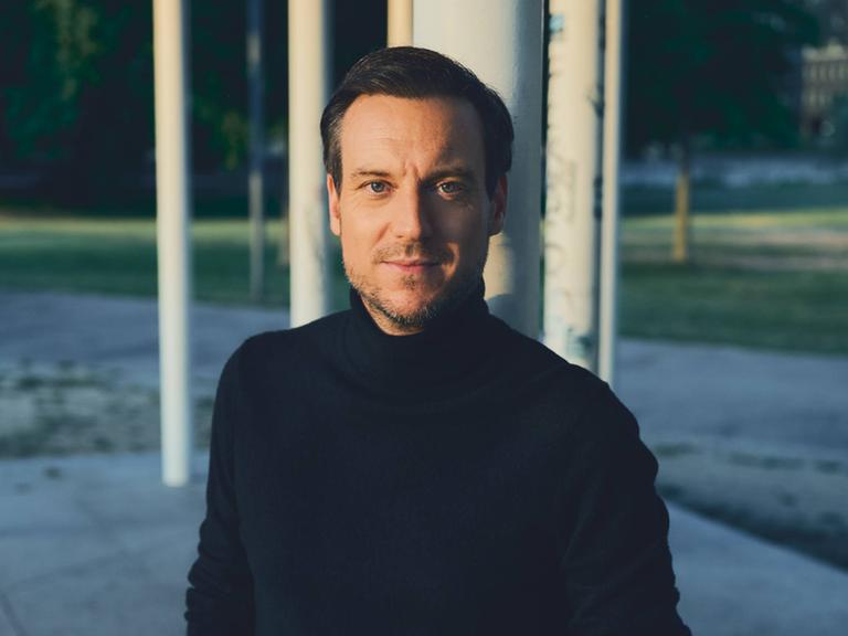Journalist und Autor Andreas Wunn schaut direkt in die Kamera. Er trägt einen schwarzen Rollkragenpullover.