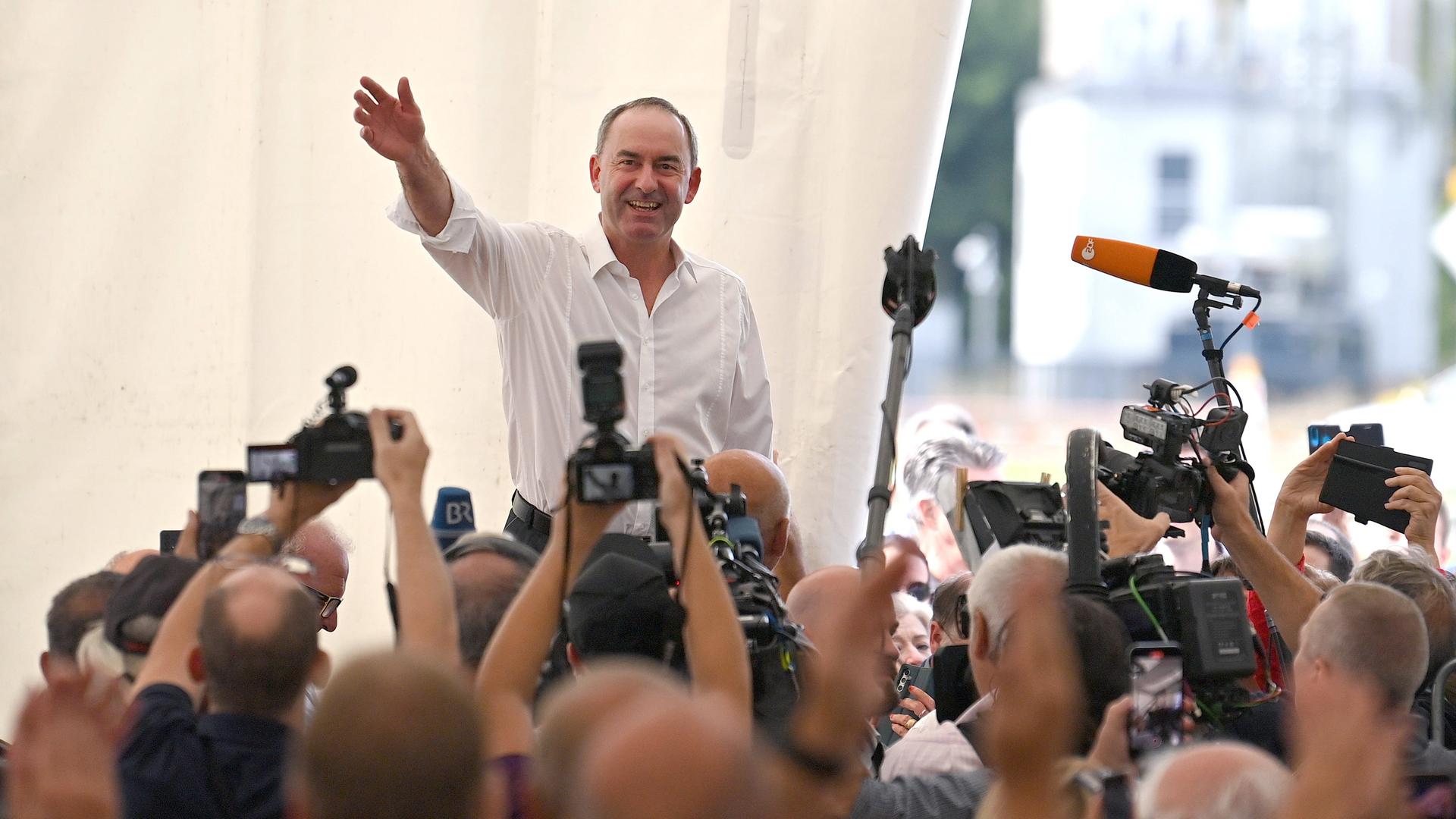 Hubert Aiwanger (Freie Wähler) winkt am 03.09.2023 nach seiner Rede am Keferloher Sonntag im Festzelt auf Gut Keferloh bei München vor Kameras und Mikrofonen in die Menge. 