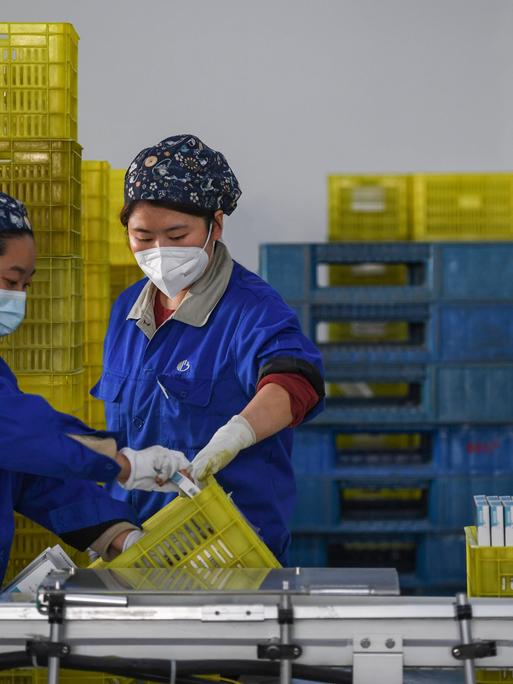 Angestellte verpacken Medikamente in der Fabrik eines pharmazeutischen Unternehmens. 