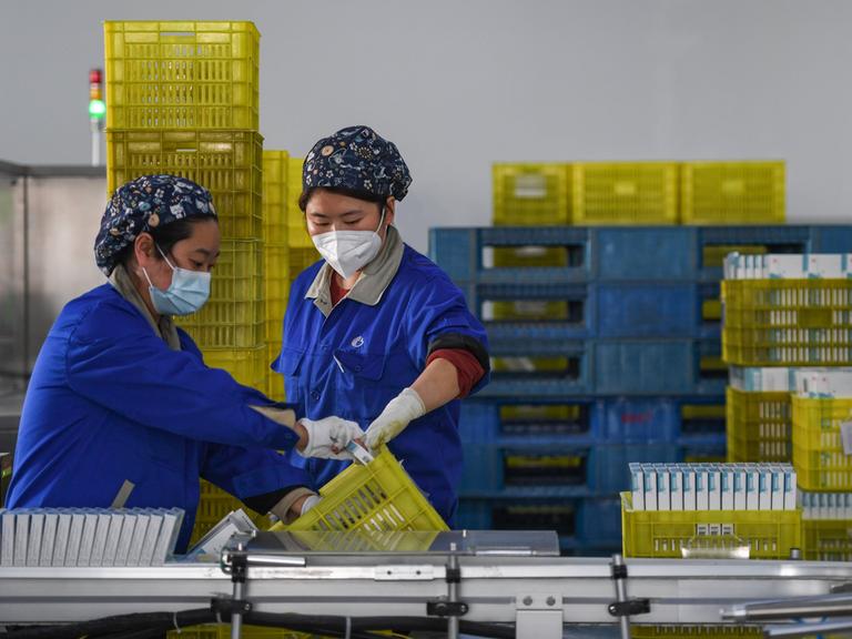 Angestellte verpacken Medikamente in der Fabrik eines pharmazeutischen Unternehmens. 