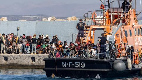 Migranten, die vor der griechischen Insel Kreta aus dem Meer gerettet wurden, gehen im Hafen von Agia Galini von einem Rettungsboot der griechischen Küstenwache an Land. 