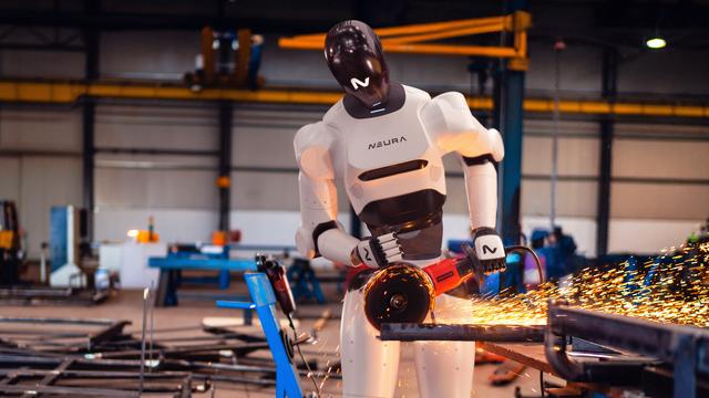 Ein humanoider Roboter (4NE1) der Firma "Neura Robotics" steht an einem Winkelschleifer in einer Industriehalle und verrichtet gefährliche Arbeiten, Funken fliegen direkt neben den Beinen des Roboters Ein humanoider Roboter (4NE1) der Firma "Neura Robotics" steht an einem Winkelschleifer in einer Industriehalle und verrichtet gefährliche Arbeiten, Funken fliegen direkt neben den Beinen des Roboters