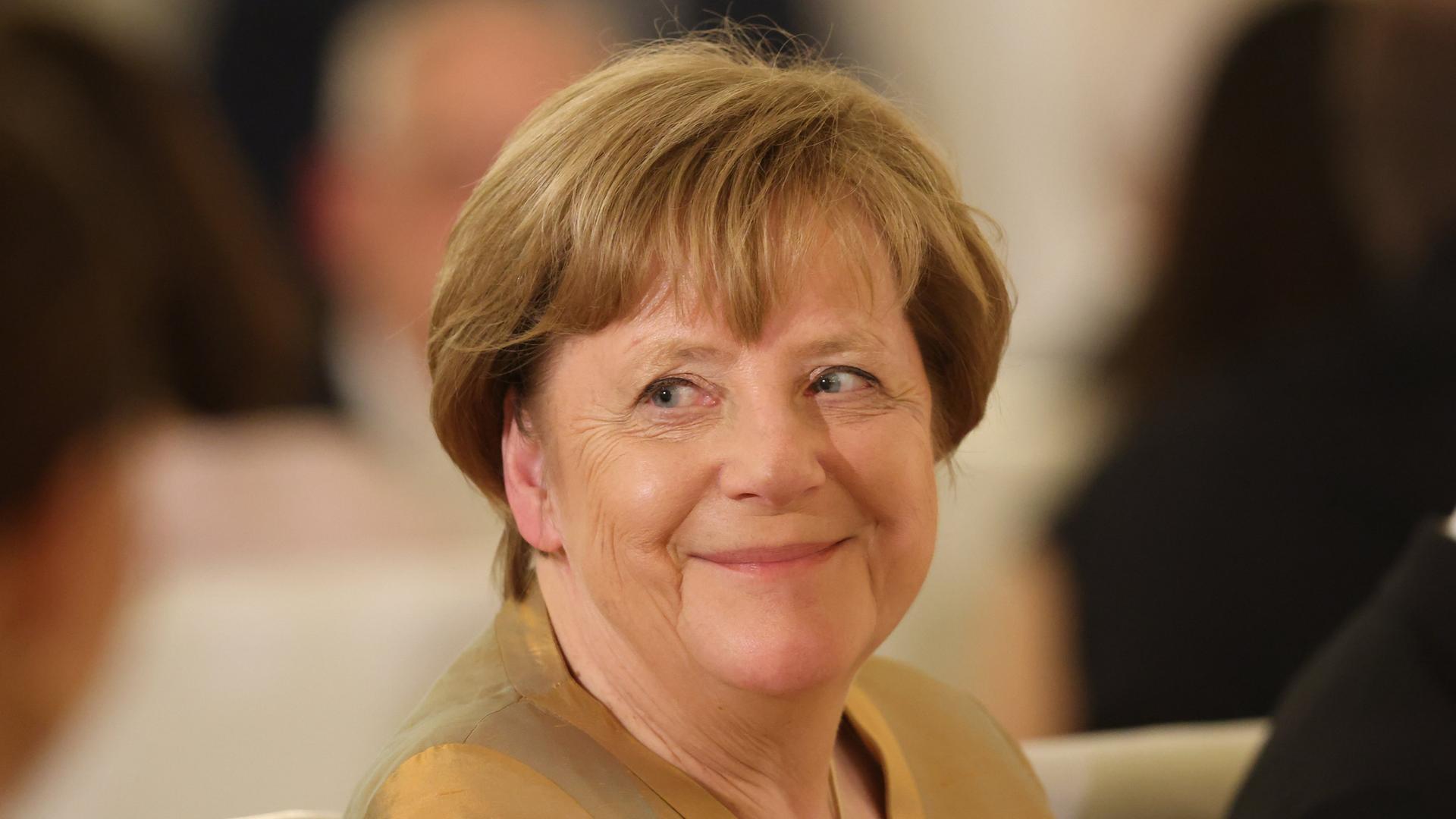 Angela Merkel sitzt bei einem Staatsbankett zu Ehren von König Charles im Schloss Bellevue.