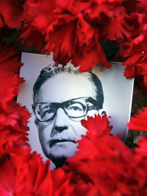 Rote Blumen umrunden ein Foto des früheren Präsidenten von Chile, Salvador Allende. 