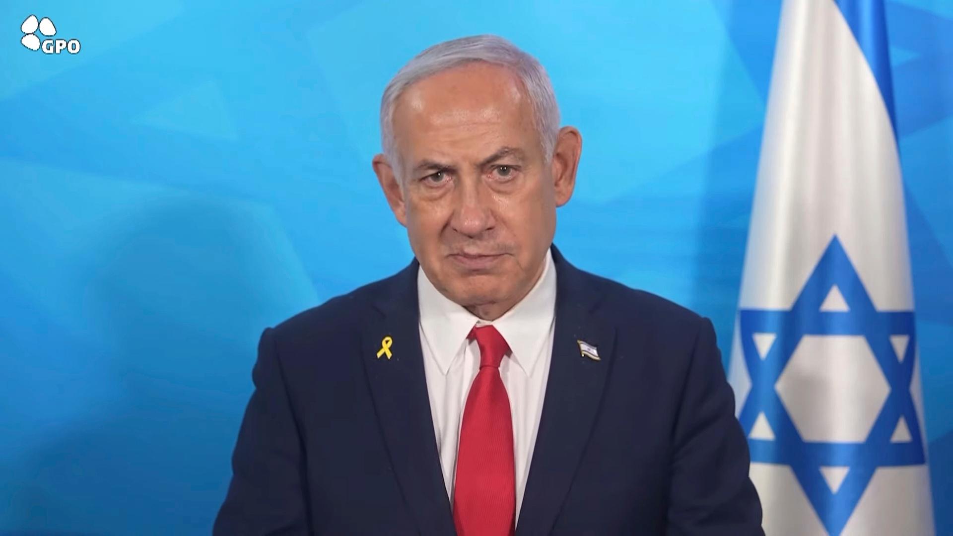 In diesem Bild aus einem vom Presseamt der israelischen Regierung veröffentlichten Video gibt der israelische Ministerpräsident Benjamin Netanjahu eine Erklärung ab. Er steht neben einer israelischen Fahne. In diesem Bild aus einem vom Presseamt der israelischen Regierung veröffentlichten Video gibt der israelische Ministerpräsident Benjamin Netanjahu eine Erklärung ab. Er steht neben einer israelischen Fahne.