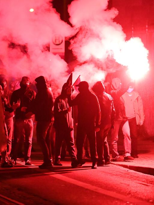 Teilnehmer einer Demonstration ziehen mit roten Pyro-Fackeln durch den Leipziger Stadtteil Connewitz, 2020. 