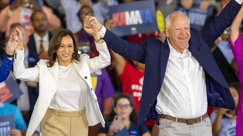 Das Bild zeigt Kamala Harris und Tim Walz jubelnd.