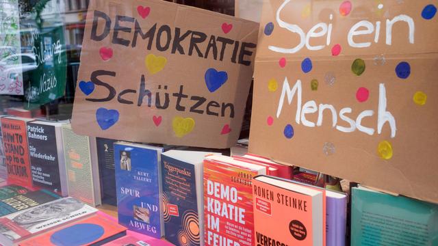 Schaufenster einer Buchhandlung in Köln, das mit geliehenen Schildern von Demonstrationen gegen Rechtsextremismus dekoriert wurde.