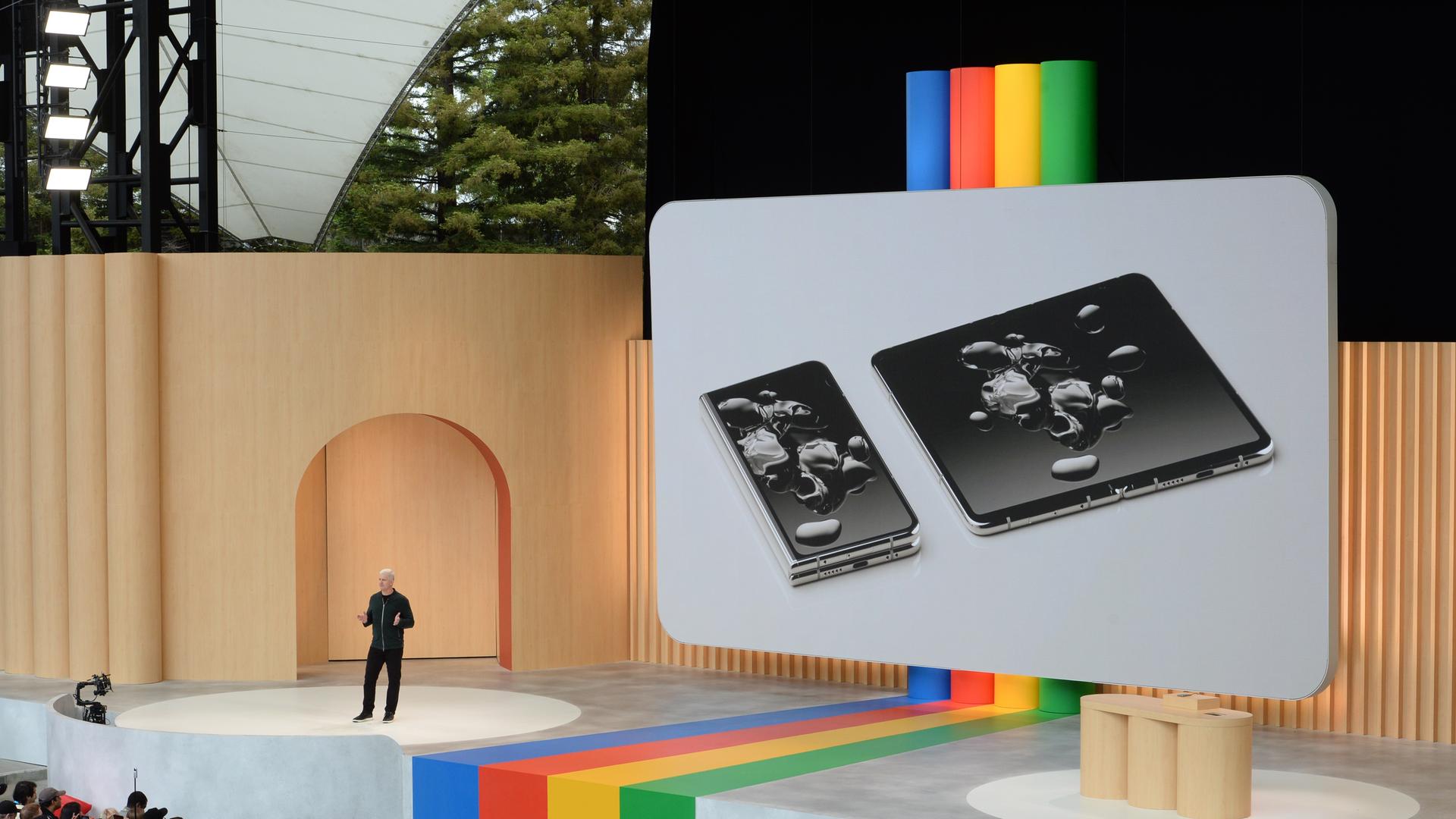 Mountain View: Googles Gerätechef Rick Osterloh stellt das faltbare Smartphone Pixel Gold bei der Entwicklerkonferenz Google I/O vor. Es ist groß auf einer Leinwand auf der Bühne zu sehen. Mountain View: Googles Gerätechef Rick Osterloh stellt das faltbare Smartphone Pixel Gold bei der Entwicklerkonferenz Google I/O vor. Es ist groß auf einer Leinwand auf der Bühne zu sehen.