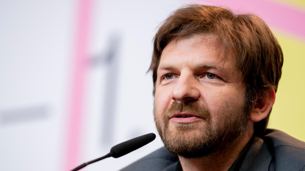 Der bärtige Regisseur Visar Morina sitzt hinter einem Mikrofon