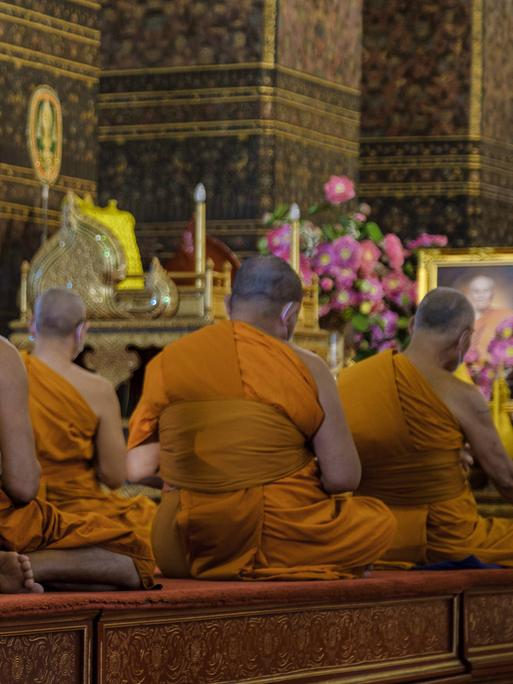 Buddhistische Mönche meditieren im Wat Pho Tempel in Bangkok.