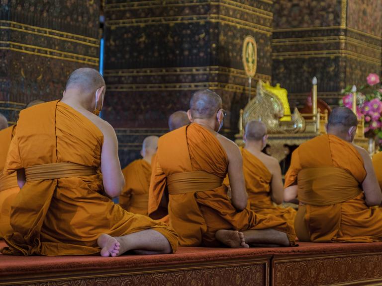 Buddhistische Mönche meditieren im Wat Pho Tempel in Bangkok.