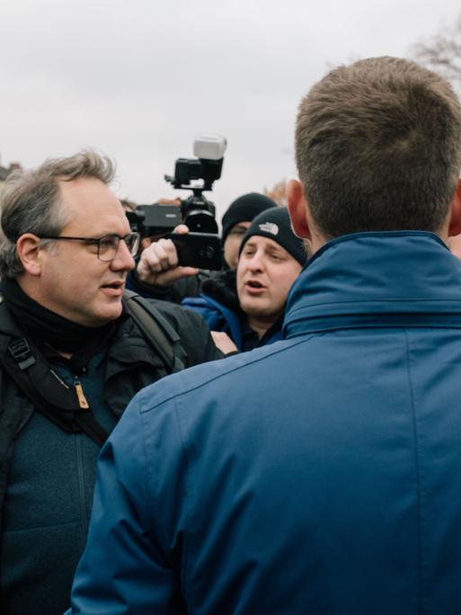 David Janzen steht am 23.11.2019 bei einem NPD-Aufmarsch gegen Journalistinnen in Hannover zwischen Neonazis