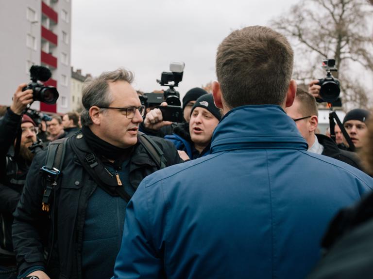 David Janzen steht am 23.11.2019 bei einem NPD-Aufmarsch gegen Journalistinnen in Hannover zwischen Neonazis