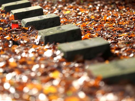 Eine Trauerkerze steht neben den Grabsteinen von russischen Kriegsgefangenen, die in Essen während des zweiten Weltkrieges ums Leben kamen. 