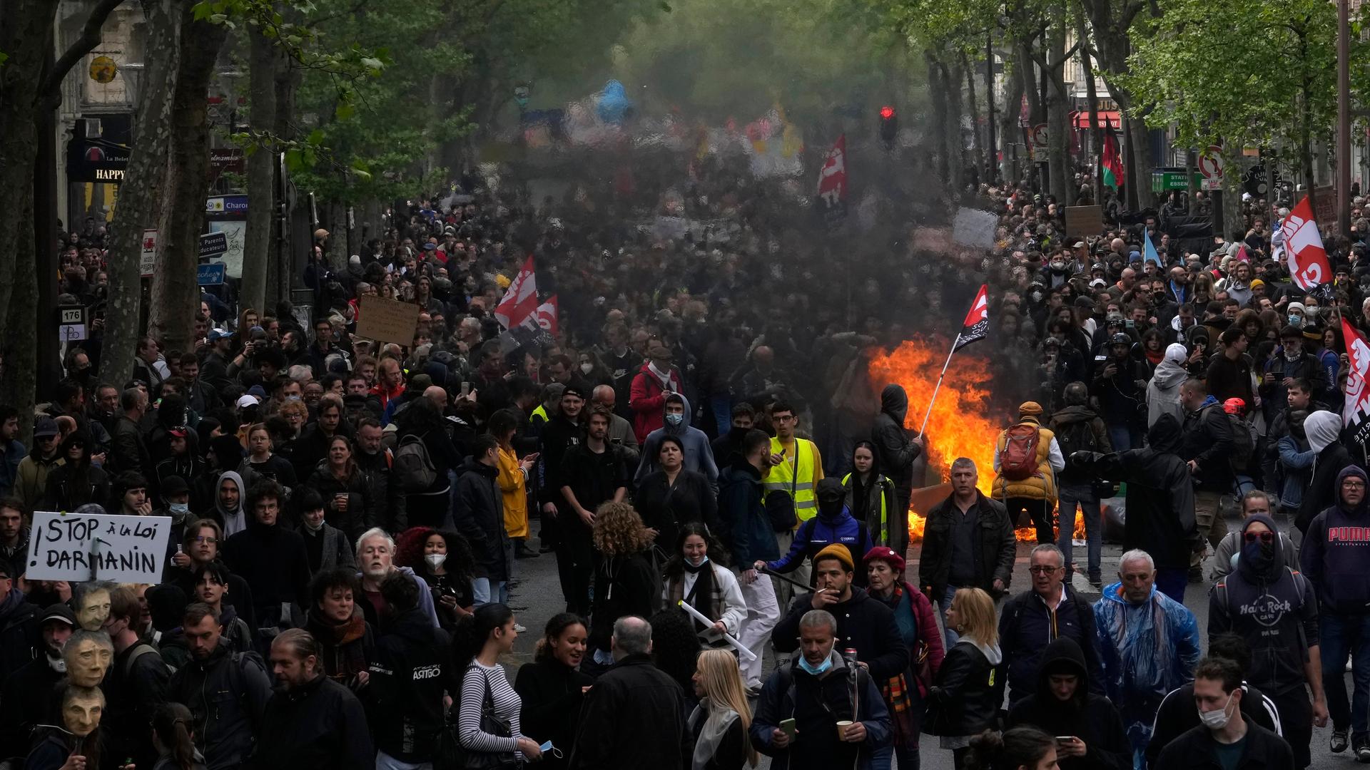 Das Foto zeigt Teilnehmer der Mai-Demonstration in der französischen Hauptstadt Paris. In der Menschenmenge brennt ein Feuer. Das Foto zeigt Teilnehmer der Mai-Demonstration in der französischen Hauptstadt Paris. In der Menschenmenge brennt ein Feuer.
