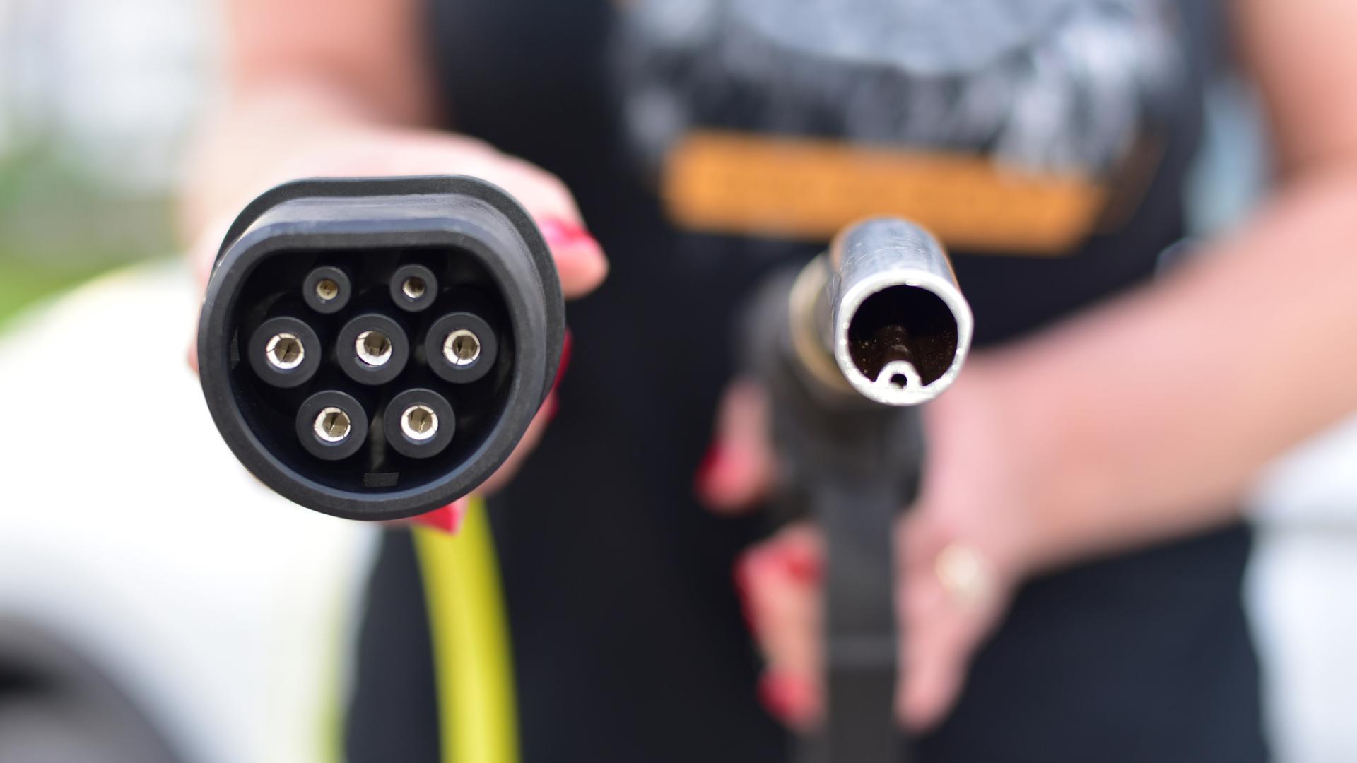 Ein Zapfhahn für die Betankung von Diesel oder Benzin betriebenen Fahrzeugen rechts, links ein Stecker zum Laden von Elektrofahrzeugen.