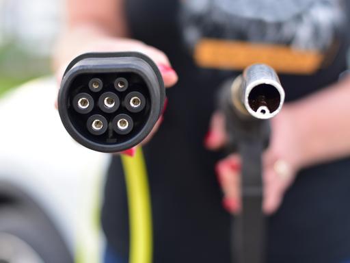 Ein Zapfhahn für die Betankung von Diesel oder Benzin betriebenen Fahrzeugen rechts, links ein Stecker zum Laden von Elektrofahrzeugen.