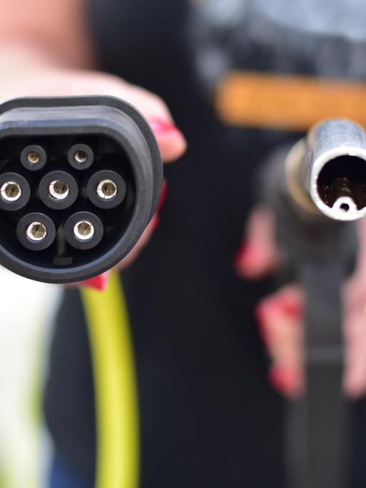 Ein Zapfhahn für die Betankung von Diesel oder Benzin betriebenen Fahrzeugen rechts, links ein Stecker zum Laden von Elektrofahrzeugen.