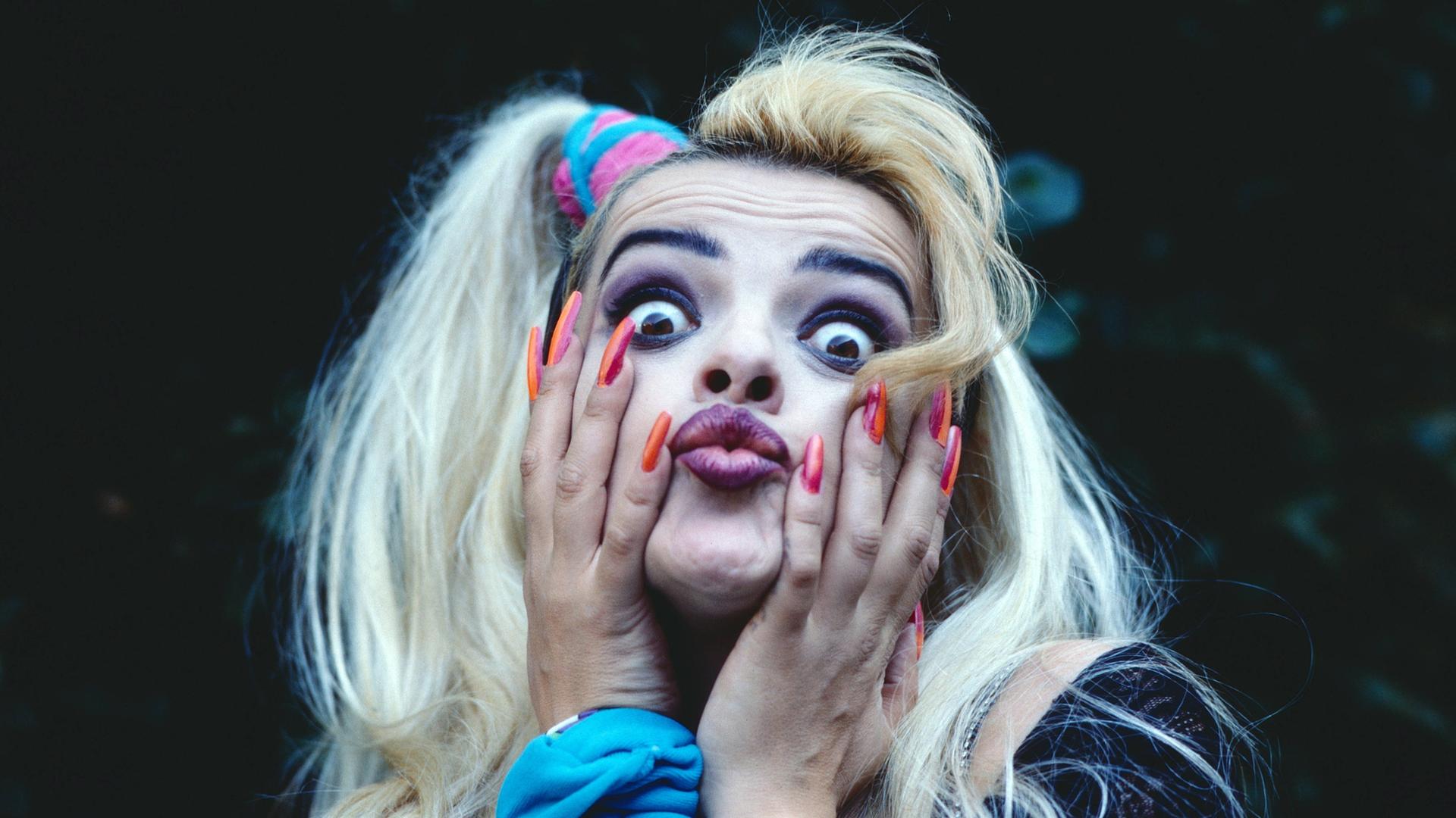 Porträt von Nina Hagen 1985 mit blondierten Haaren und langen roten Fingernägeln. 