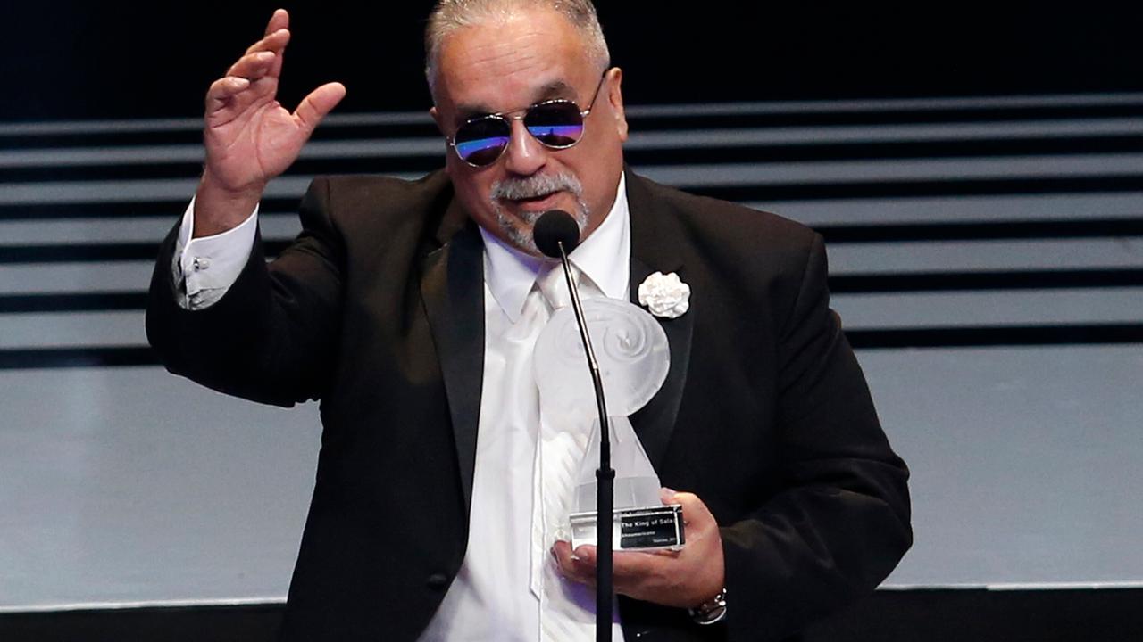 Der Musiker Willie Colon bei der Entgegennahme eines Preises in Mexico City. Er trägt eine Sonnenbrille. Die Auszeichnung hält er in der linken Hand, die rechte hat er wie zum Gruß erhoben. 