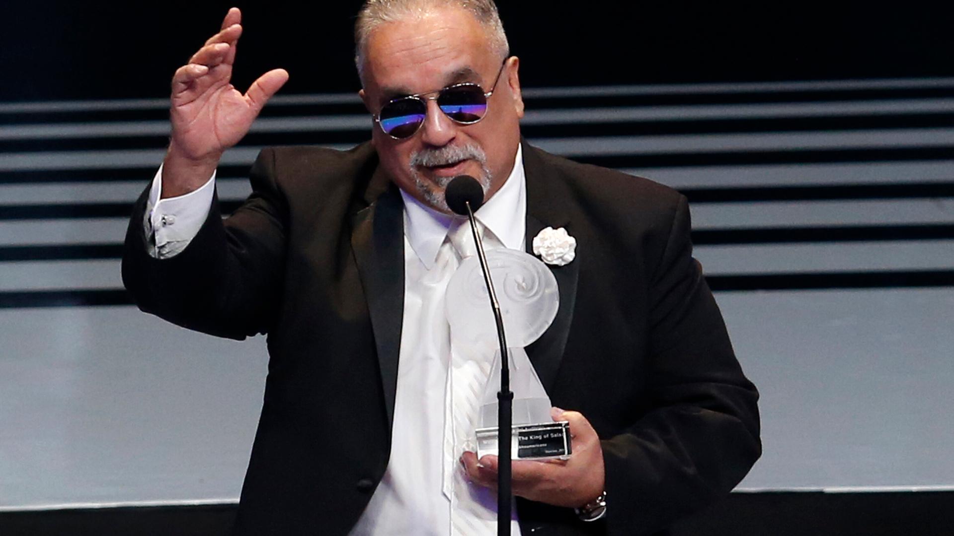 Der Musiker Willie Colon bei der Entgegennahme eines Preises in Mexico City. Er trägt eine Sonnenbrille. Die Auszeichnung hält er in der linken Hand, die rechte hat er wie zum Gruß erhoben. Der Musiker Willie Colon bei der Entgegennahme eines Preises in Mexico City. Er trägt eine Sonnenbrille. Die Auszeichnung hält er in der linken Hand, die rechte hat er wie zum Gruß erhoben.