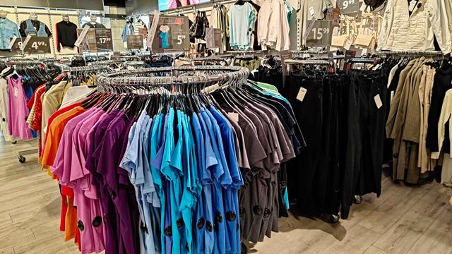 Kleider-Ständer mit T-Shirts in einem Mode-Geschäft