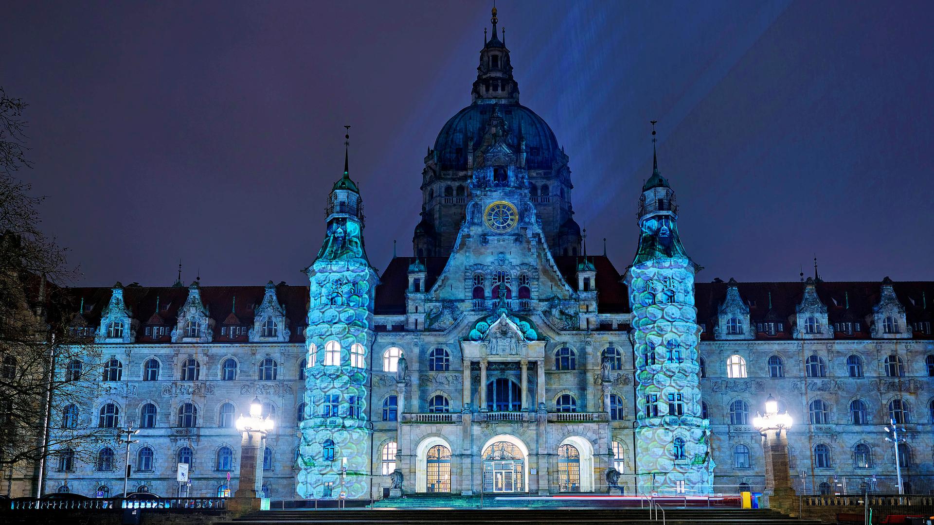 Das Rathaus wird mit blauen Laserlichtern illuminiert. 