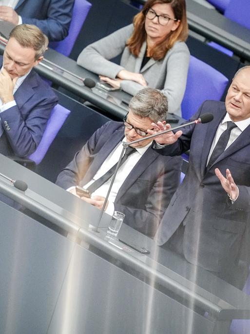 Bundeskanzler Olaf Scholz (SPD) spricht bei der Regierungsbefragung im Bundestag neben Finanzminister Christian Lindner (FDP) und Wirtschaftsminister Robert Habeck zu den Abgeordneten.