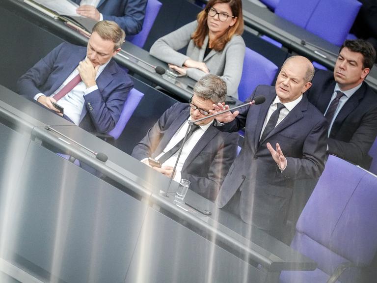 Bundeskanzler Olaf Scholz (SPD) spricht bei der Regierungsbefragung im Bundestag neben Finanzminister Christian Lindner (FDP) und Wirtschaftsminister Robert Habeck zu den Abgeordneten.