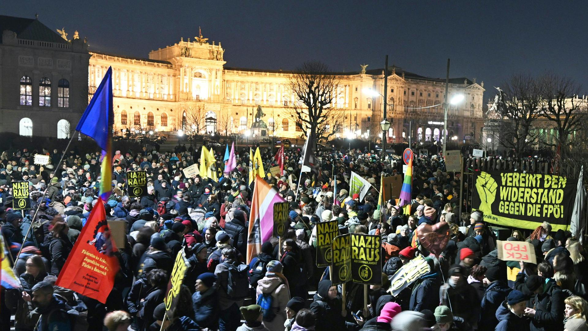 Das Foto zeigt viele Menschen dicht gedrängt auf einem großen Platz. Einige halten Fahnen und Transparente in die Höhe. 