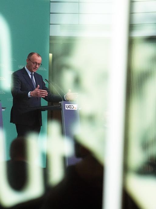 CDU-Chef Friedrich Merz (M) und sein Generalsekretär Carsten Linnemann bei einer Pressekonferenz nach der Sitzung des CDU-Vorstands. Auf der Scheibe im Vordergund ist das Konterfei von Kornad Adenauer zu sehen.