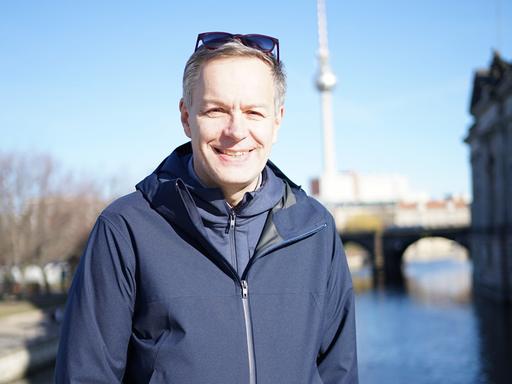 Steffen Möller steht auf einer Berliner Brücke. Im Hintergrund ist der Berliner Fernsehturm zu sehen.