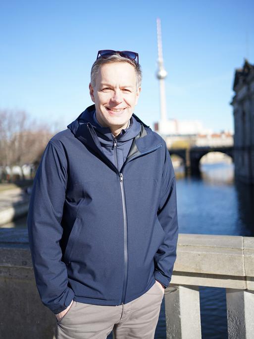 Steffen Möller steht auf einer Berliner Brücke. Im Hintergrund ist der Berliner Fernsehturm zu sehen.