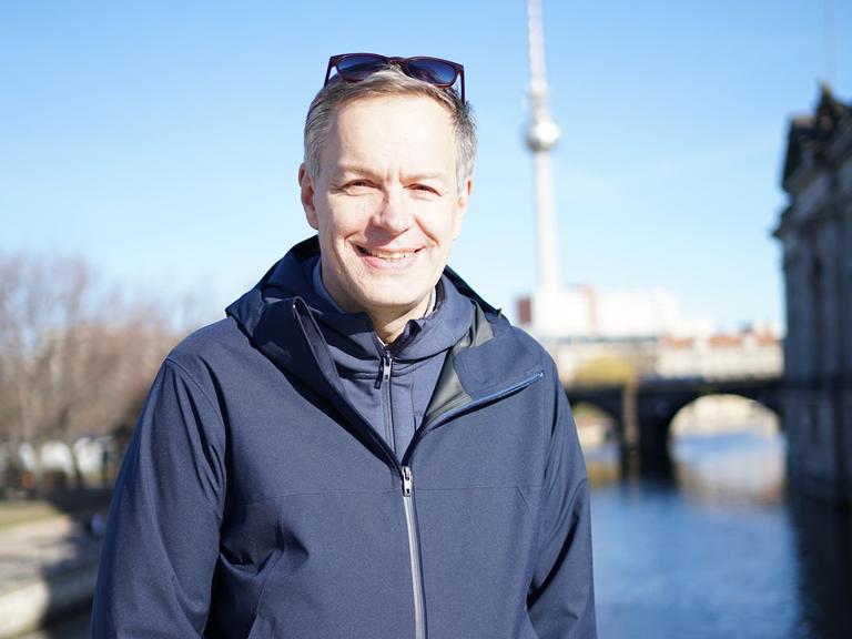 Steffen Möller steht auf einer Berliner Brücke. Im Hintergrund ist der Berliner Fernsehturm zu sehen.