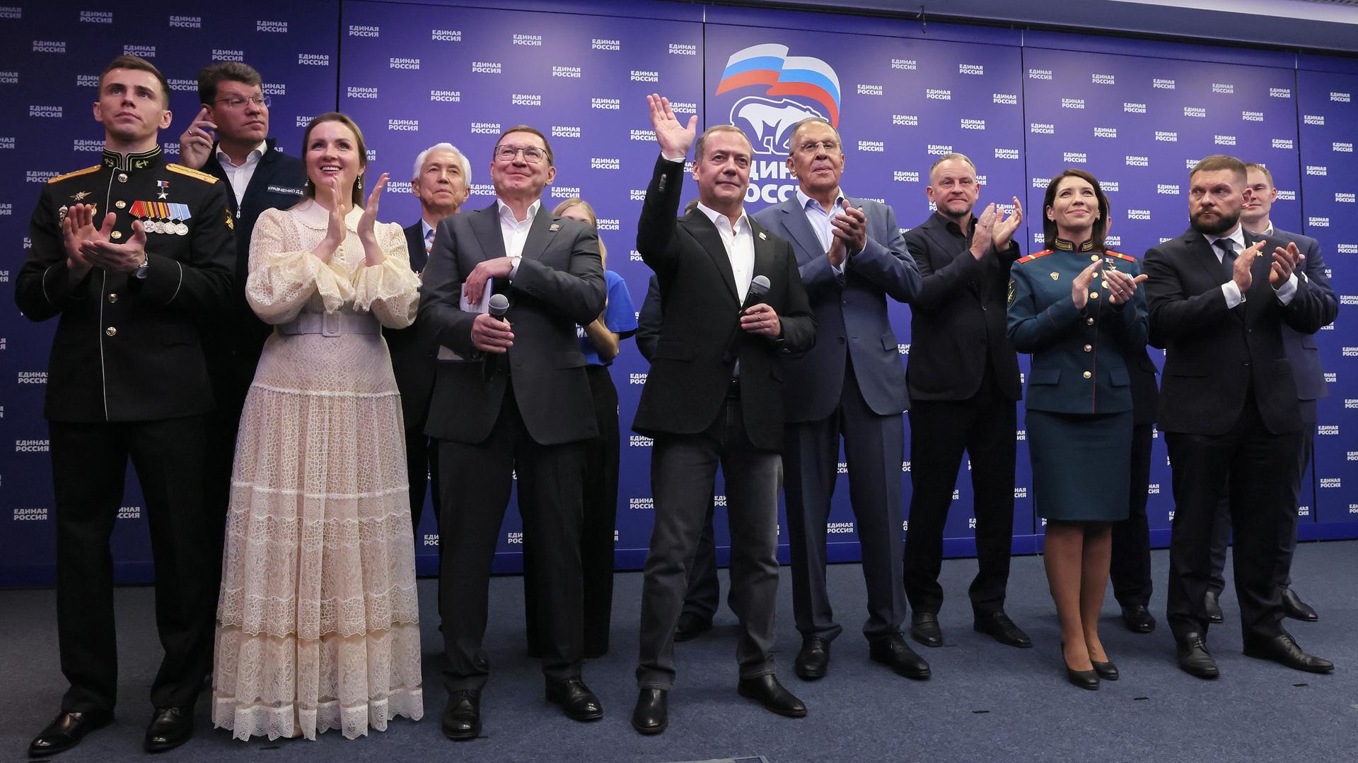 Der stellvertretende Vorsitzende des russischen Sicherheitsrates und Vorsitzende der Partei Geeintes Russland, Dmitri Medwedew (M), sowie der russische Außenminister Sergej Lawrow (M, r) stehen mit anderen Parteimitgliedern nebeneinander.