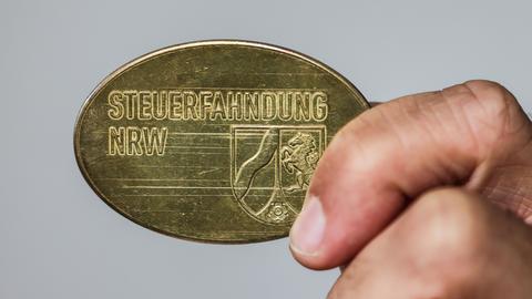 Ein Mitarbeiter im Landesamt zur Bekämpfung der Finanzkriminalität (LBF) zeigt eine Dienstmarke mit der Aufschrift "Steuerfahndung NRW".