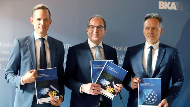 Hendrik Streeck, Alexander Dobrindt und Holger Münch (v.li.) halten Infobroschüren in Händen bei der Pressekonferenz Bundeslagebilder Organisierte Kriminalität und Rauschgiftkriminalität im Bundeskriminalamt.