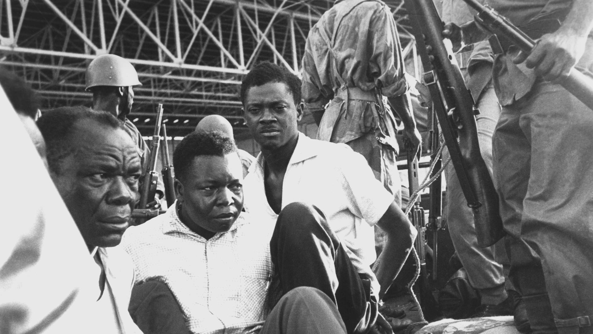 Patrice Lumumba (Mitte hinten), erster Ministerpräsident der Demokratischen Republik Kongo, sitzt nach seiner Verhaftung am 2. Dezember 1960 in einem offenen Armeefahrzeug und ist an den Händen gefesselt. 